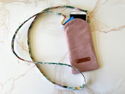 Pink glasses case with a phone and card on a marble surface