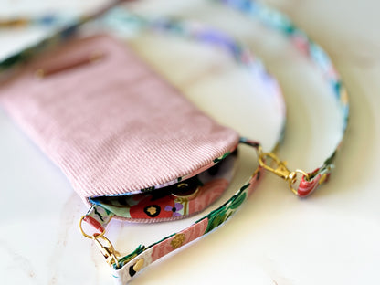 Pink phone case with a colorful strap on a light background